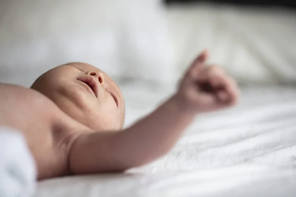 Close up of a cute young baby laying in a crib. Low angle view — Stock Photo, Image
