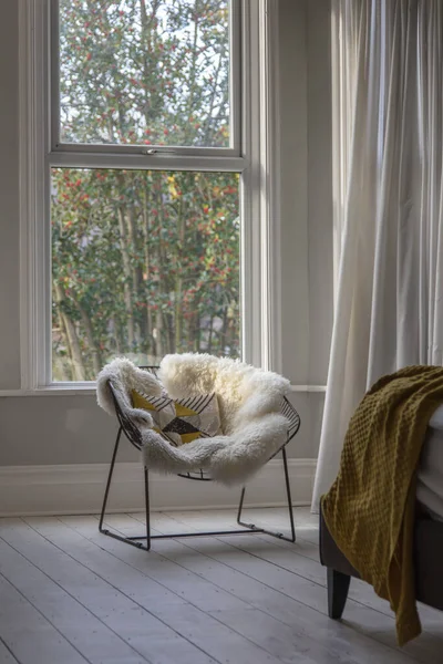 Modern armchair covered in soft furnishings in a bright bedroom — Stock Photo, Image