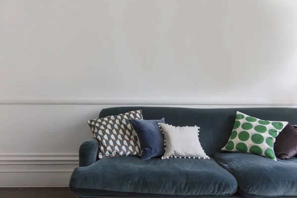 Comfortable blue sofa in a against a plain wall. Interior design — Stock Photo, Image