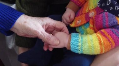Sevimli çocuk ve büyükanne el ele tutuşur. Yaşlanma kavramı