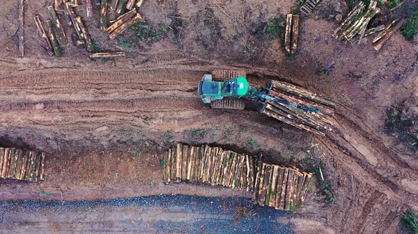 Kereste ağır makinelerle çamurlu bir yolda taşınıyor. Hava görünümü — Stok fotoğraf