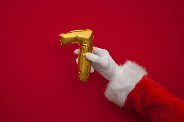 12 dni świąt. Santa ręce gospodarstwa 7 dzień balon na czerwonym tle — Zdjęcie stockowe