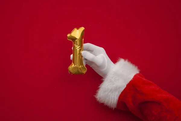 12 dni świąt. Santa ręce gospodarstwa 1 dzień balon na czerwonym tle — Zdjęcie stockowe