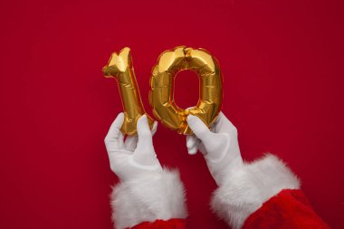 Noel 'in 12 günü. Noel Baba elleri kırmızı arka planda 10. gün balonunu tutuyor.