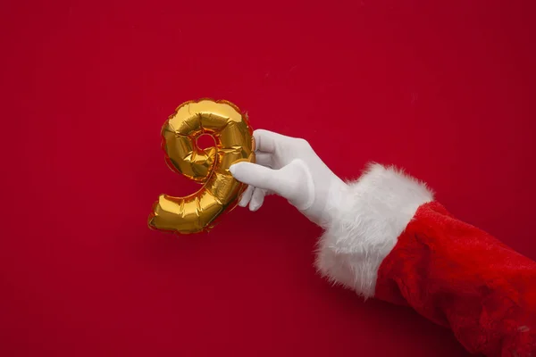 12 dni świąt. Santa ręce gospodarstwa 9 dzień balon na czerwonym tle — Zdjęcie stockowe