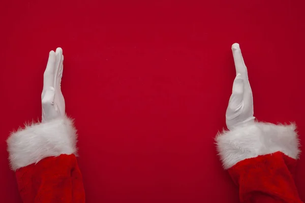 Santa Claus робить рамку з руками на червоному тлі з копіювальним простором. — стокове фото