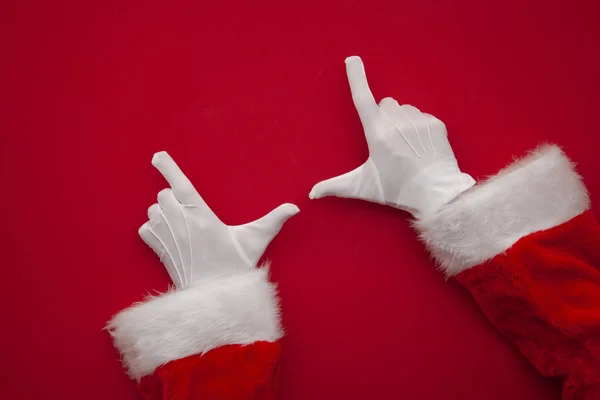 Santa Claus podejmowania ramki z ręki na czerwonym tle z miejsca kopiowania — Zdjęcie stockowe