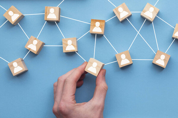 Рука выбирает деревянный блок из набора. Концепция выбора бизнеса