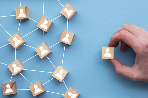 Рука выбирает деревянный блок из набора. Концепция выбора бизнеса