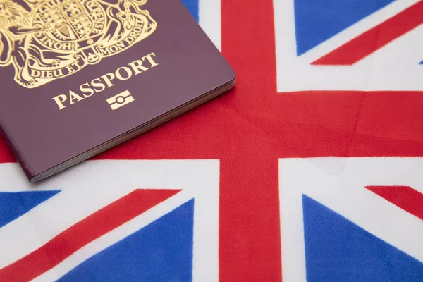 Reino Unido passaporte de viagem em uma bandeira da União Jack da Grã-Bretanha — Fotografia de Stock
