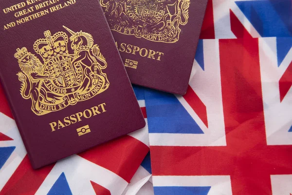 Reino Unido passaporte de viagem em uma bandeira da União Jack da Grã-Bretanha — Fotografia de Stock