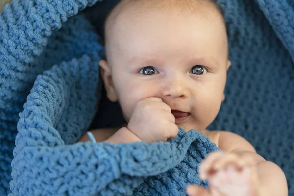 A cute baby boy hugging a soft blue blanket — Stock Photo, Image