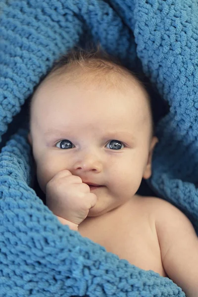 A cute baby boy hugging a soft blue blanket — Stock Photo, Image