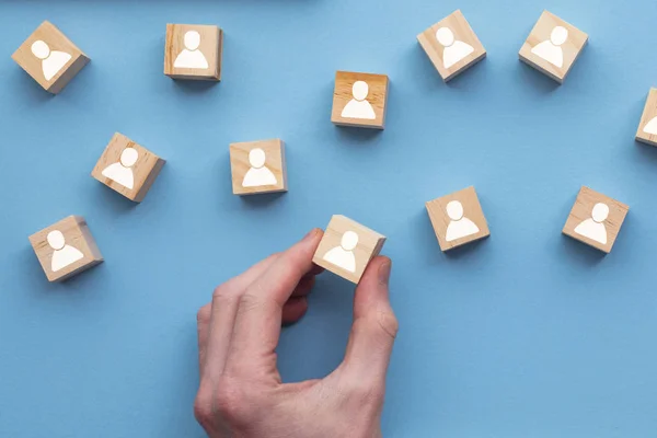 Mano elegir un bloque de madera persona de un conjunto. Concepto de elección de empleo —  Fotos de Stock