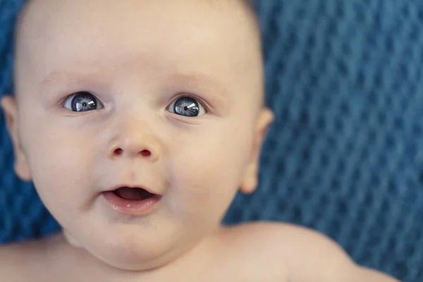 Close up de um bebê com olhos azuis brilhantes olhando para a câmera — Fotografia de Stock