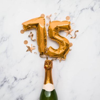 75 numaralı balonla şampanya şişesi. Asgari parti yıldönümü konsepti