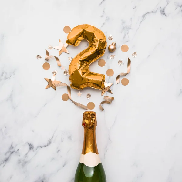 Bottiglia di champagne con palloncino numero 2 in oro. Concetto di anniversario del partito minimo — Foto Stock