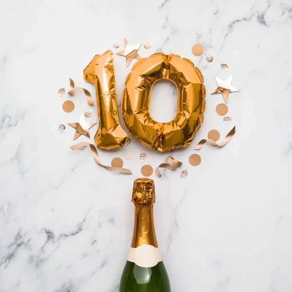 Champagne fles met gouden ballon nummer 10. Minimaal verjaardagsconcept — Stockfoto