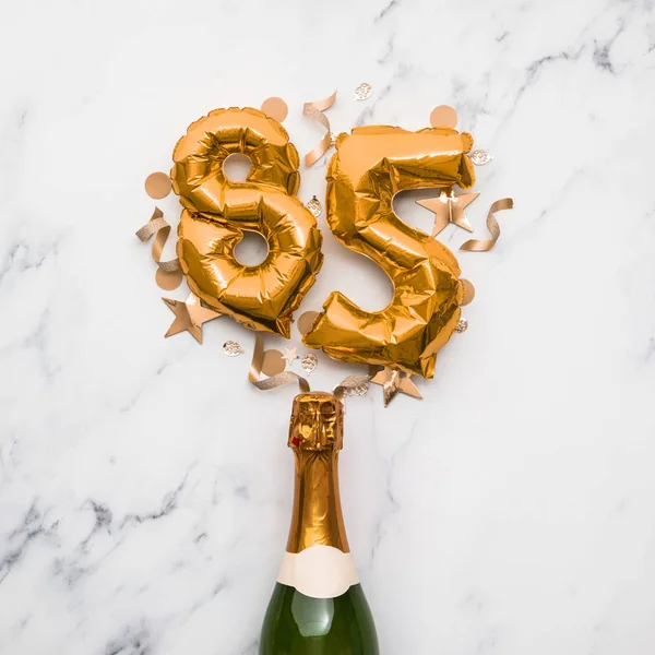 Champagne fles met gouden nummer 85 ballon. Minimaal verjaardagsconcept — Stockfoto