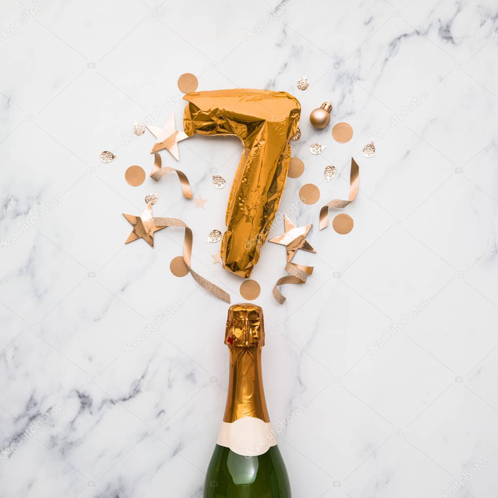 Champagne bottle with gold number 7 balloon. Minimal party anniversary concept