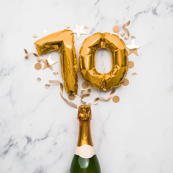 Butelka szampana ze złotym balonem numer 70. Koncepcja minimalnej rocznicy przyjęcia — Zdjęcie stockowe