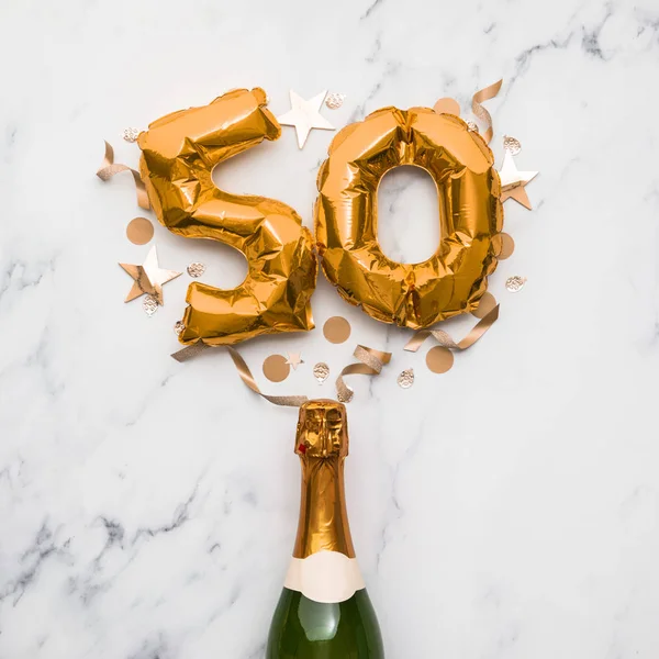 Champagne flaska med guld nummer 50 ballong. Minimalt festjubileumskoncept — Stockfoto
