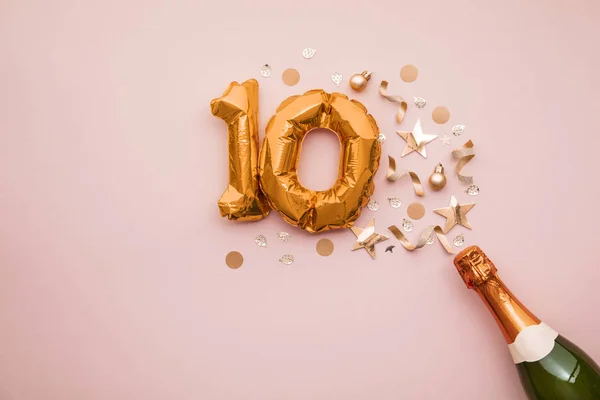 Happy 10th anniversary party. Champagne bottle with gold number balloon. — Stock Photo, Image