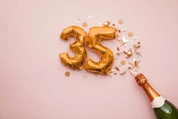 Feliz aniversário de 35 anos. Garrafa de champanhe com balão número de ouro . — Fotografia de Stock