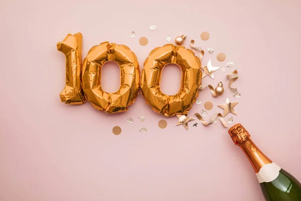 Joyeux 100e anniversaire. Bouteille de champagne avec ballon numéro or . — Photo