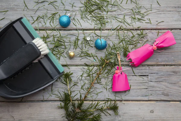 Cleaning up after christmas. Sweeping up pine needles and broken decorations — Stock Photo, Image
