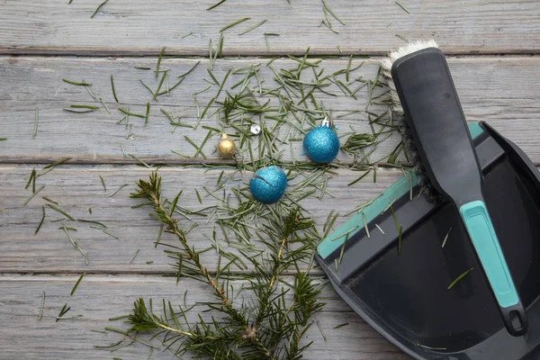 Cleaning up after christmas. Sweeping up pine needles and broken decorations — Stock Photo, Image