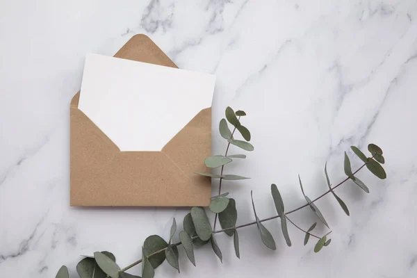 Порожня біла листівка та конверт з листям евкаліпта. Порожнє запрошення . — стокове фото