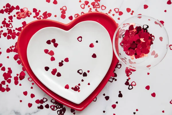 Валентинов день красные и белые тарелки с конфетти в форме сердца — стоковое фото
