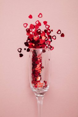 Valentines day drinks glasses with red heart confetti.
