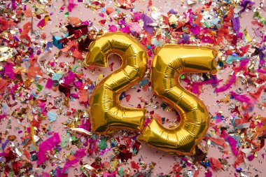 Number 25 gold birthday celebration balloon on a confetti glitter background