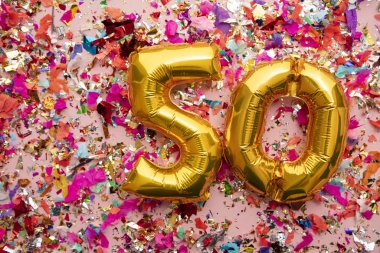Number 50 gold birthday celebration balloon on a confetti glitter background