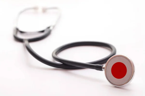 Japonský koncept zdravotní péče. Lékařský stetoskop s vlajkou země — Stock fotografie