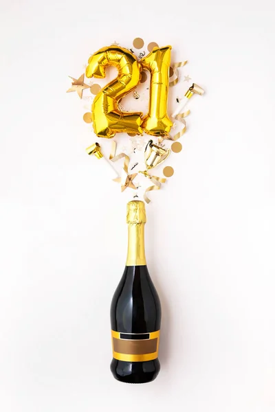 Happy 21st anniversary party. Champagne bottle with gold number balloon.