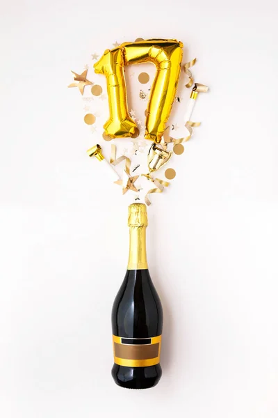 Szczęśliwej 17. rocznicy. Butelka szampana ze złotym numerem balonu. — Zdjęcie stockowe