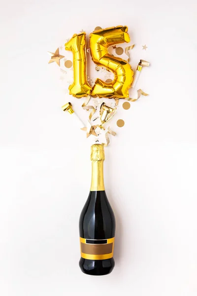 Felice quindicesimo anniversario. Bottiglia di champagne con palloncino numero oro . — Foto Stock