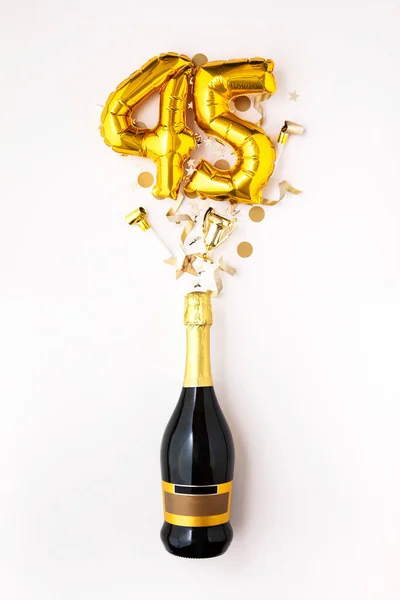 Feliz aniversário de 45 anos. Garrafa de champanhe com balão número de ouro . — Fotografia de Stock