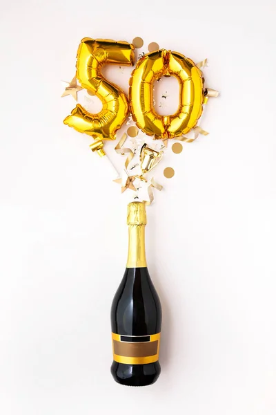 Feliz aniversário de 50 anos. Garrafa de champanhe com balão número de ouro . — Fotografia de Stock