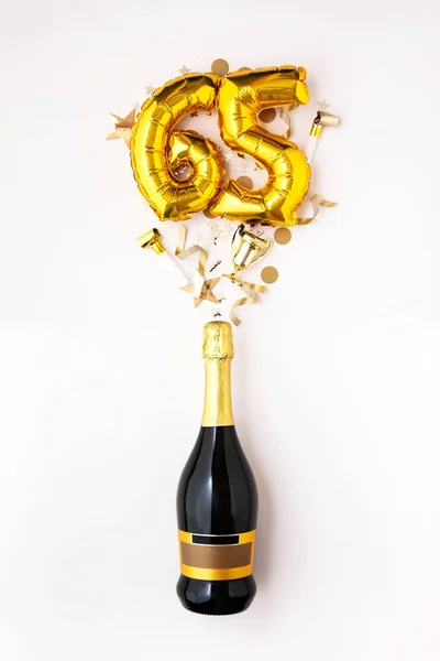 Happy 65th anniversary party. Champagne bottle with gold number balloon. — Stock Photo, Image