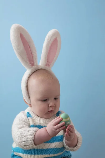 Carino bambino che indossa le orecchie di coniglio pasquale giocare con un uovo di Pasqua — Foto Stock