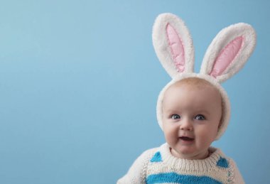 Beyaz paskalya tavşanı kulakları takan şirin bir bebek.