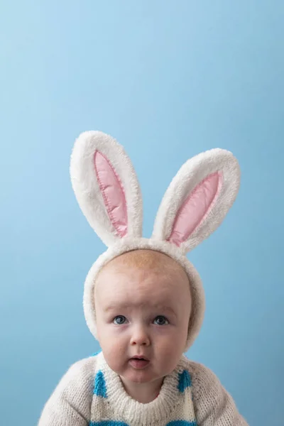 Lindo bebé con orejas de conejito de Pascua blanco sobre un fondo azul —  Fotos de Stock