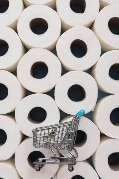 Chariot supermarché sur fond de rouleaux de papier toilette — Photo
