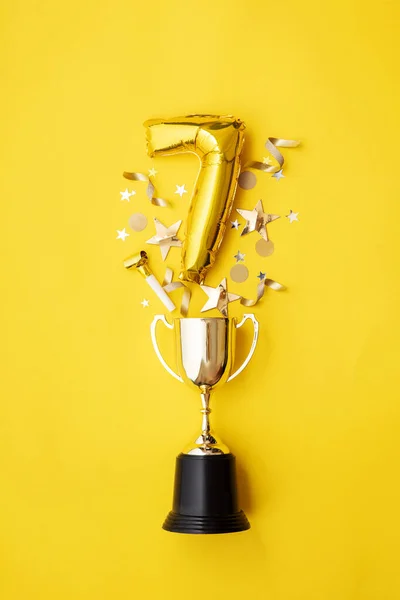 Numer 7 złota rocznica wybucha balon z zwycięskiego trofeum — Zdjęcie stockowe