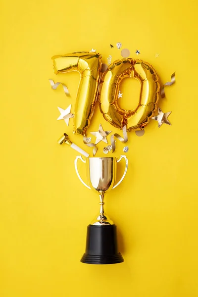 Globo de celebración del aniversario de oro número 70 explotando de un trofeo ganador —  Fotos de Stock