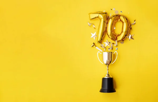 Número 70 aniversário de ouro balão celebração explodindo de um troféu vencedor — Fotografia de Stock